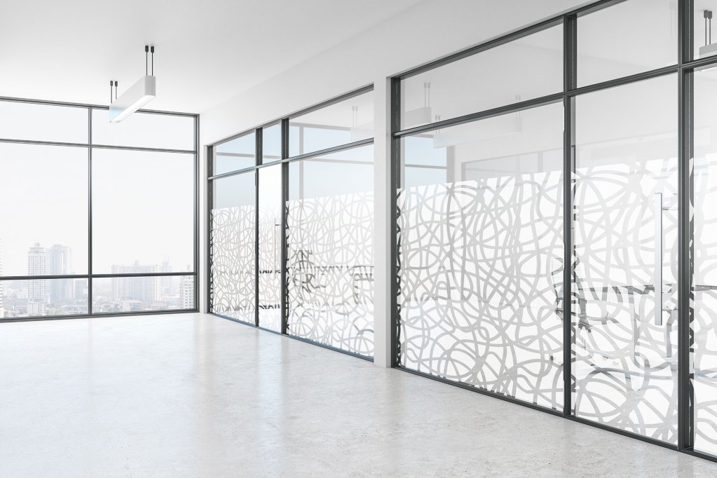 Zu sehen ist der Innenbereich eines Büros, geschützt durch eine Milchglasfolie mit einem Muster