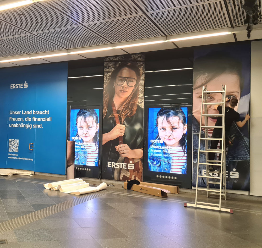 Zu sehen ist ein Bild, das eine Verklebung eines Werbesujets in einer Ubahn Station zeigt