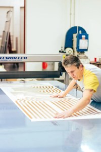 Zu sehen ist ein Folierer, der gerade eine Folie auf einem Application Tape für die Verklebung vorbereitet