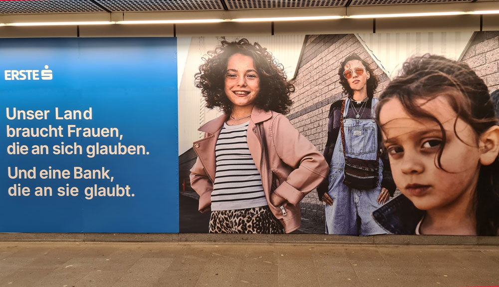 Zu sehen ist die U-Bahn Station Wien Stephansplatz verklebt mit einem Werbesujet der Erste Bank zum Weltfrauentag